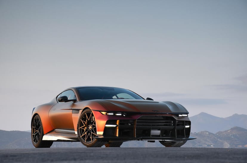 Aston Martin Valen front three-quarter view in Satin Andromeda Red showing the slatted front aero and exposed carbon fibre bodywork